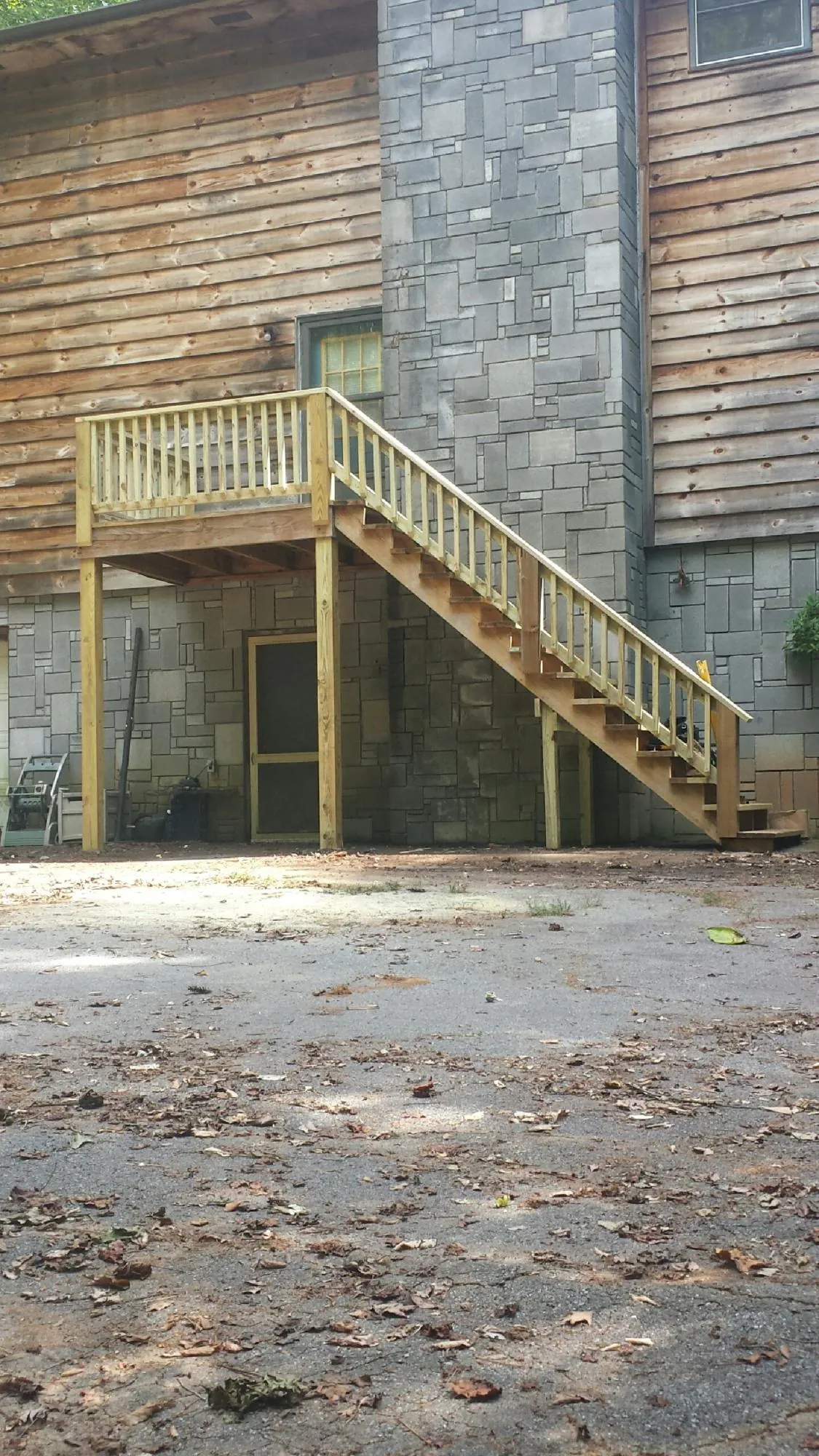 New pressure treated deck and stair landing on a log home in Waterloo